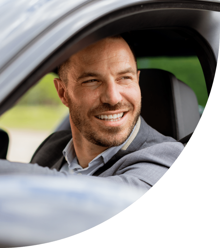 man smiling and looking out of his car window